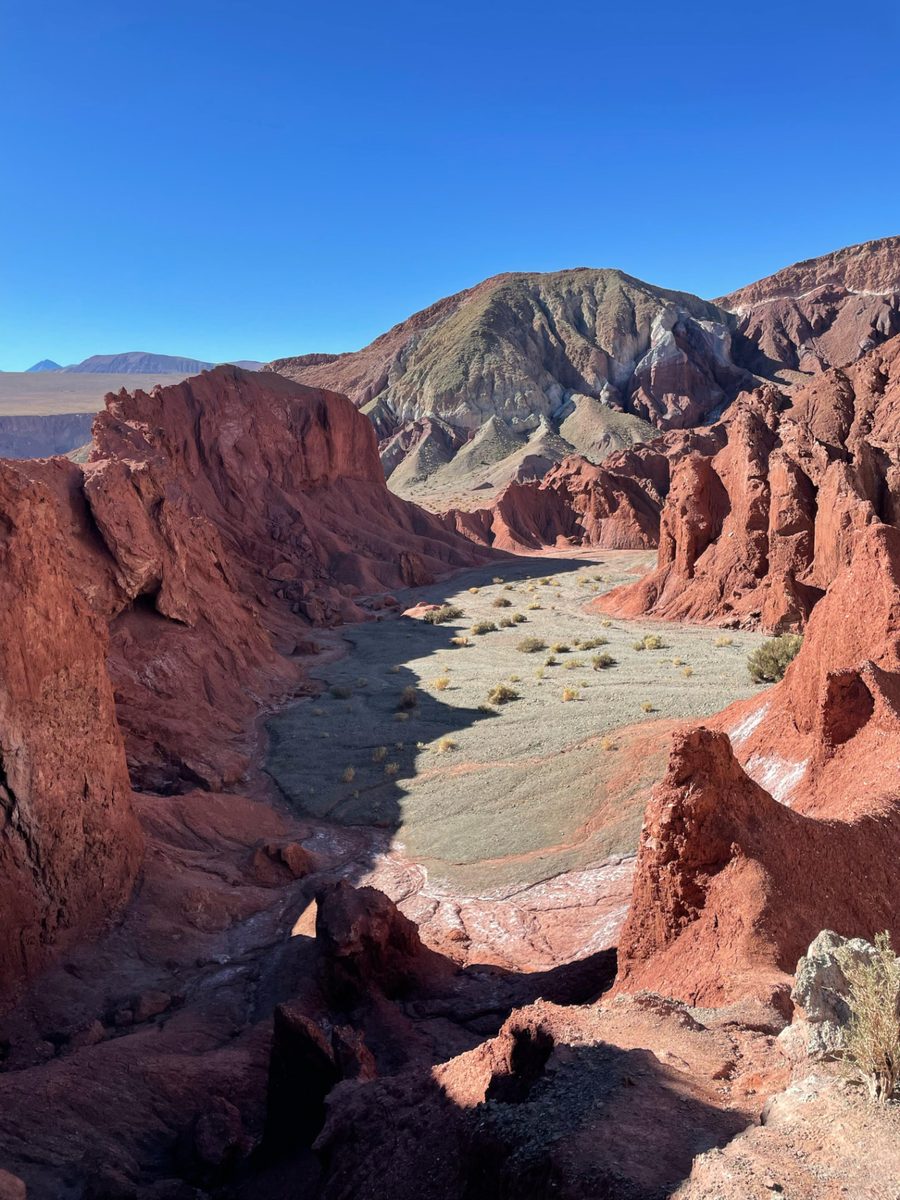 Vale do Arco-Íris com formações rochosas avermelhadas e paisagem colorida no Atacama