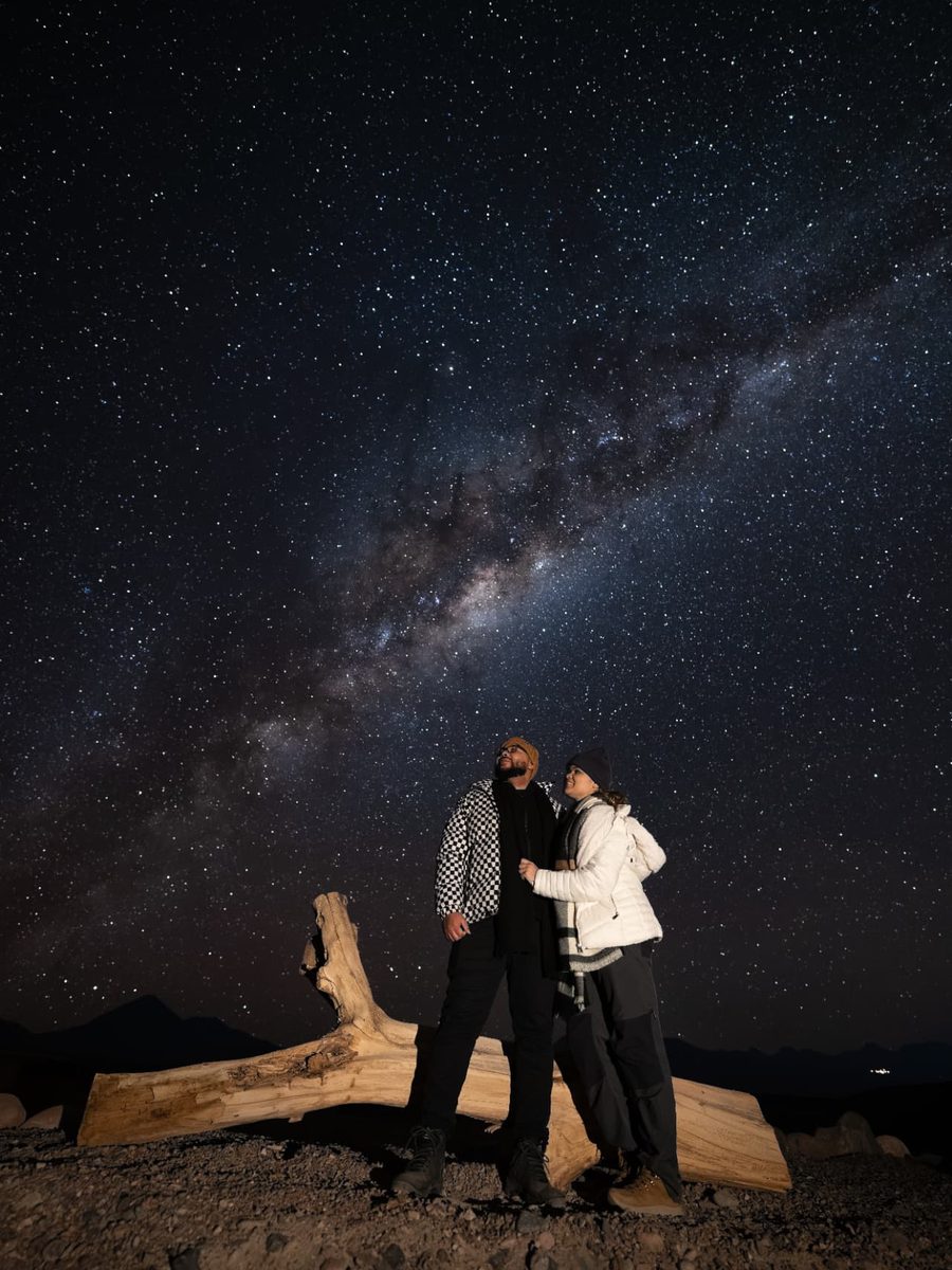 Casal observando a Via Láctea em experiência astronômica no Deserto do Atacama