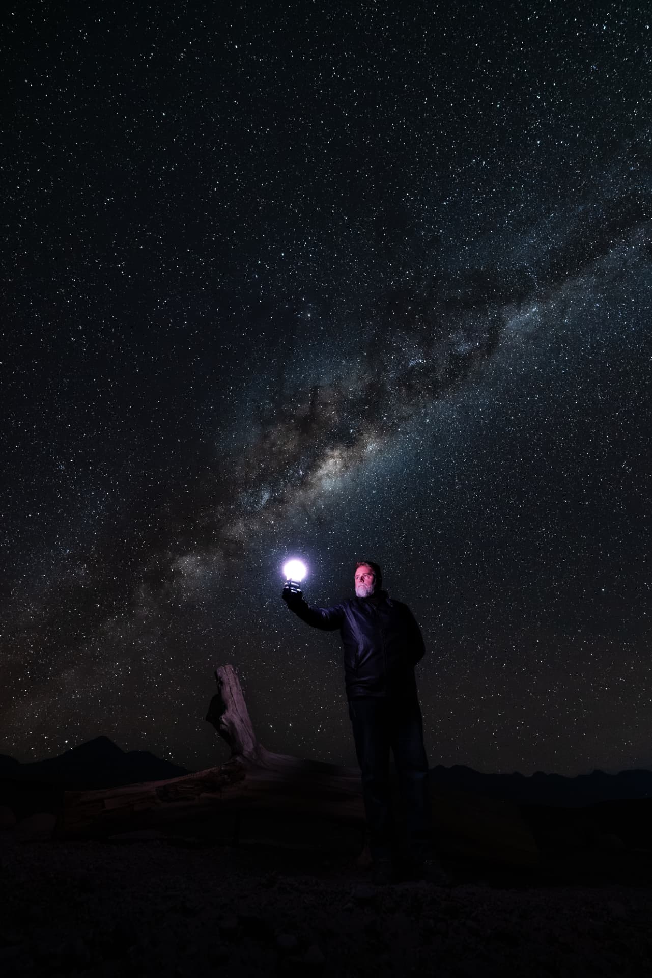 Guia segurando lanterna sob a Via Láctea no Deserto do Atacama durante experiência Tour Astronômico - Orbit 10