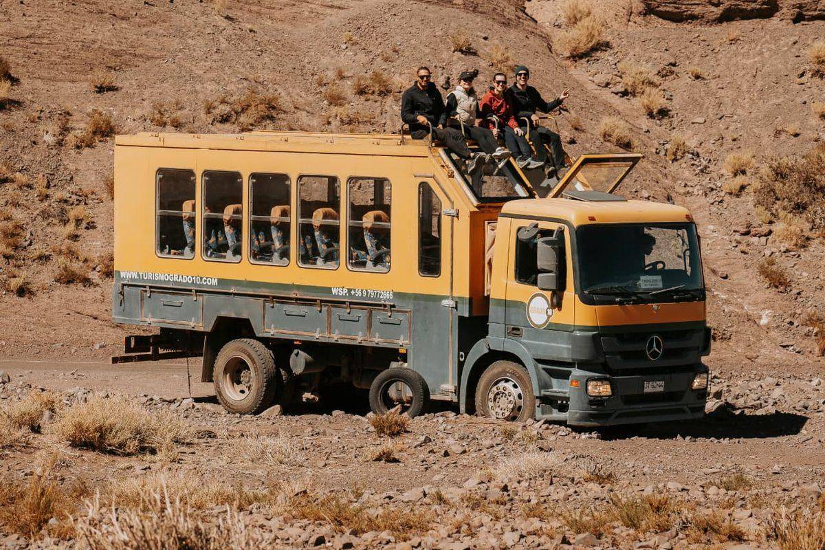 Bus Safári da Grado 10 com passageiros no terraço e paisagem desértica ao redor