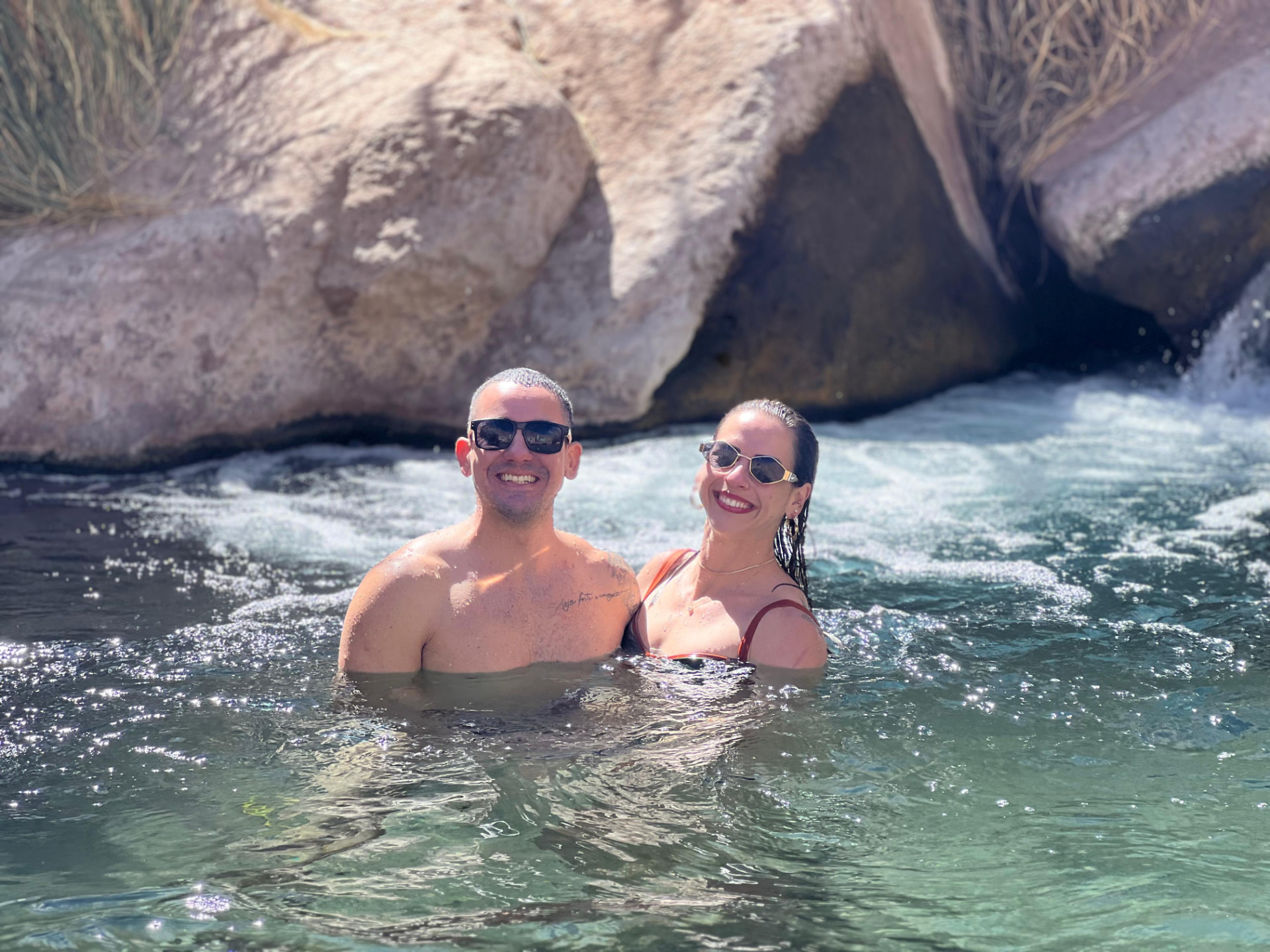 Casal relaxando nas águas termais naturais de Puritama