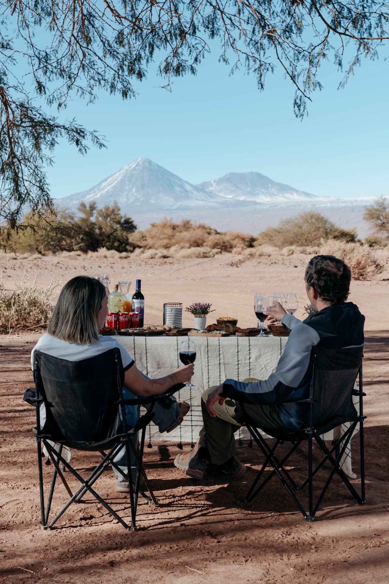 Casal em mesa posta no deserto com vista para o vulcão Licancabur