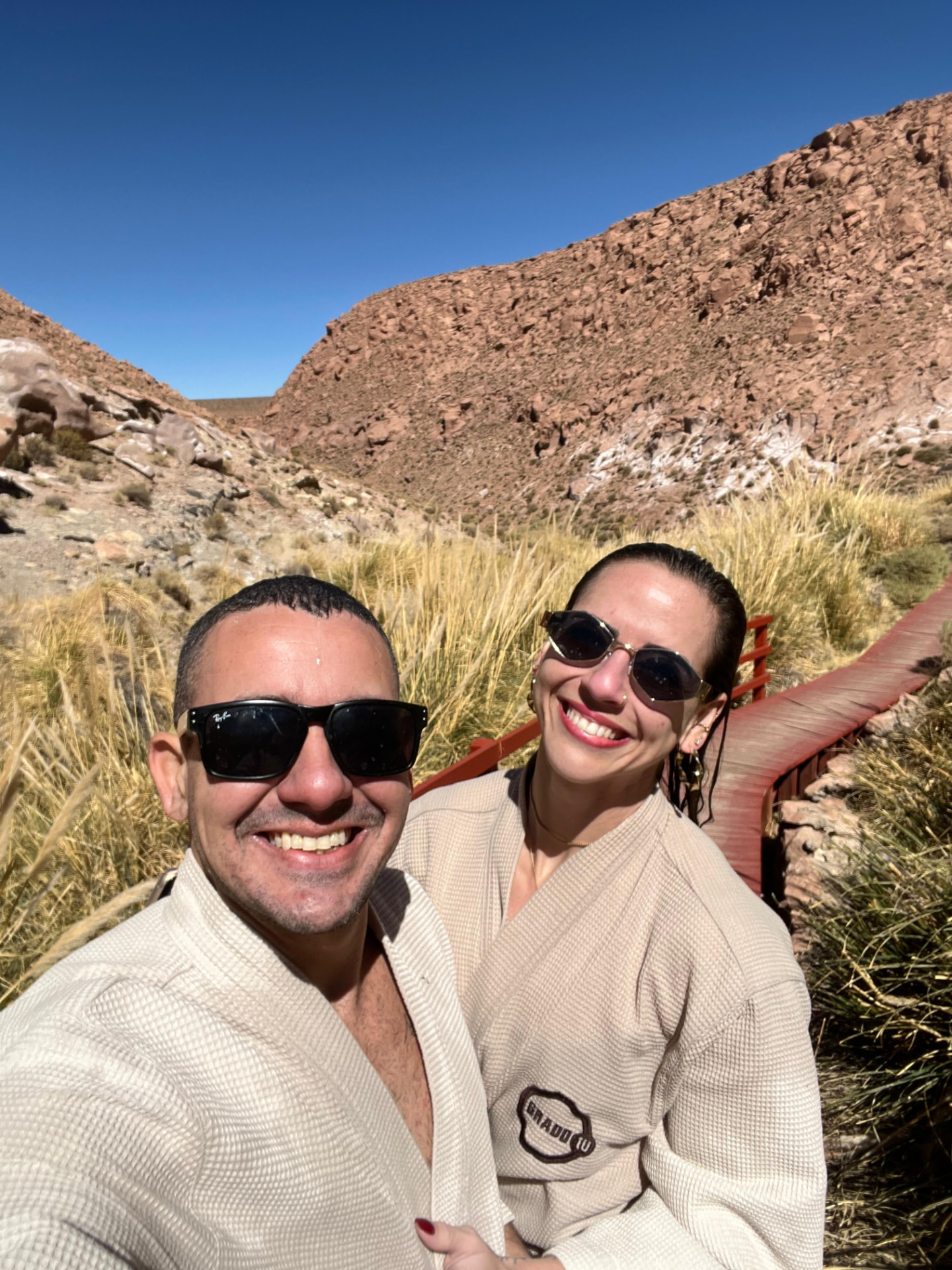 Casal de roupões nas Termas de Puritama, cercado pelas rochas do desfiladeiro