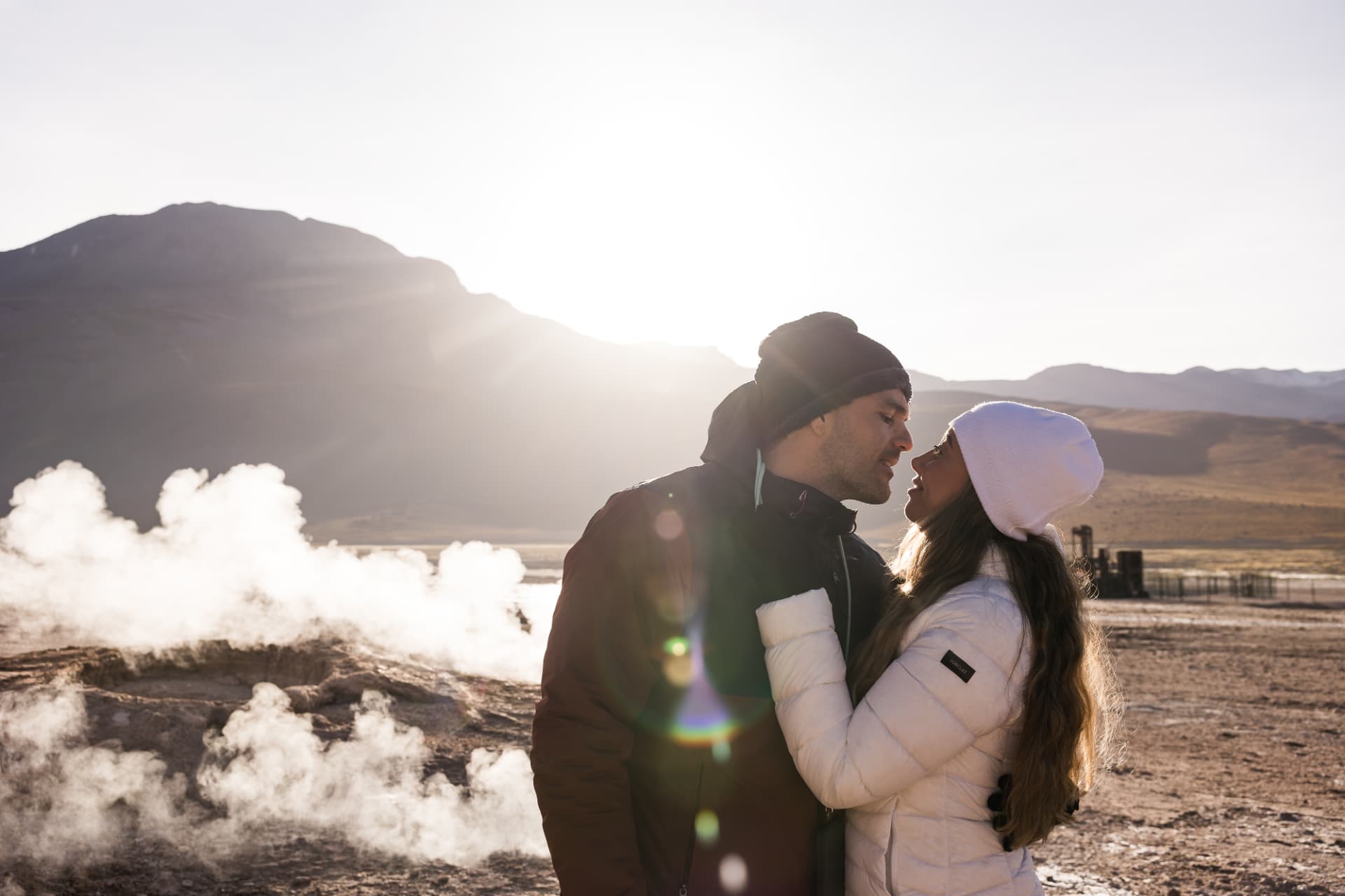 Casal em momento íntimo entre os vapores dos Gêiseres del Tatio ao amanhecer